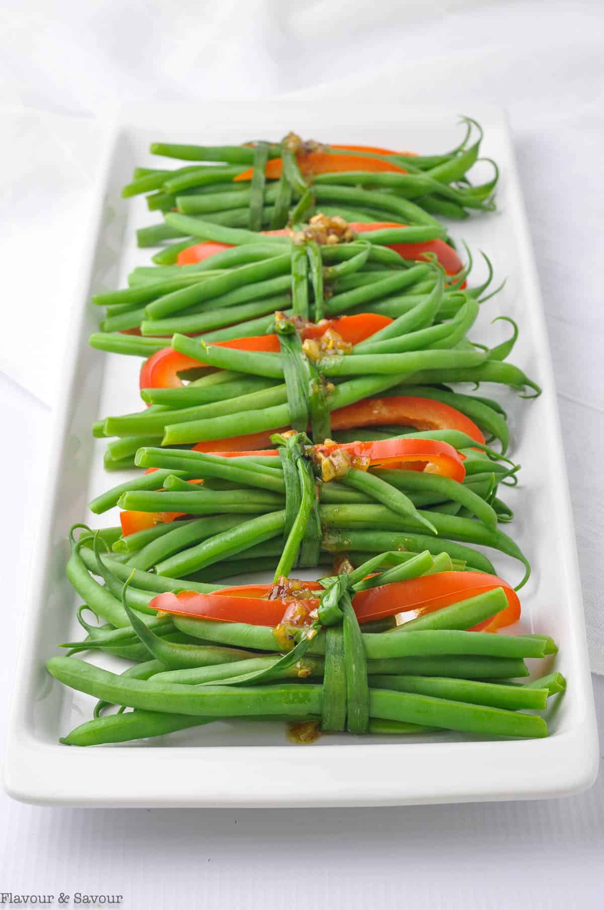 a platter of vegetarian green bean bundles tied with chives