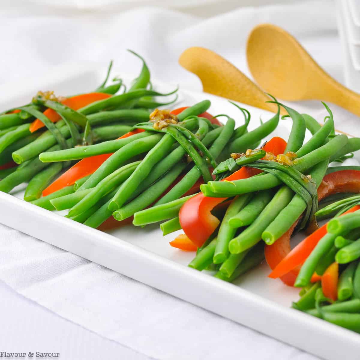 vegetarian green bean bundles with garlic butter tied with a chive ribbon