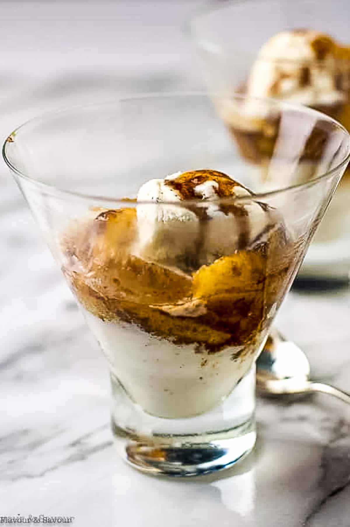 a dessert glass with bananas flambé with rum and ice cream