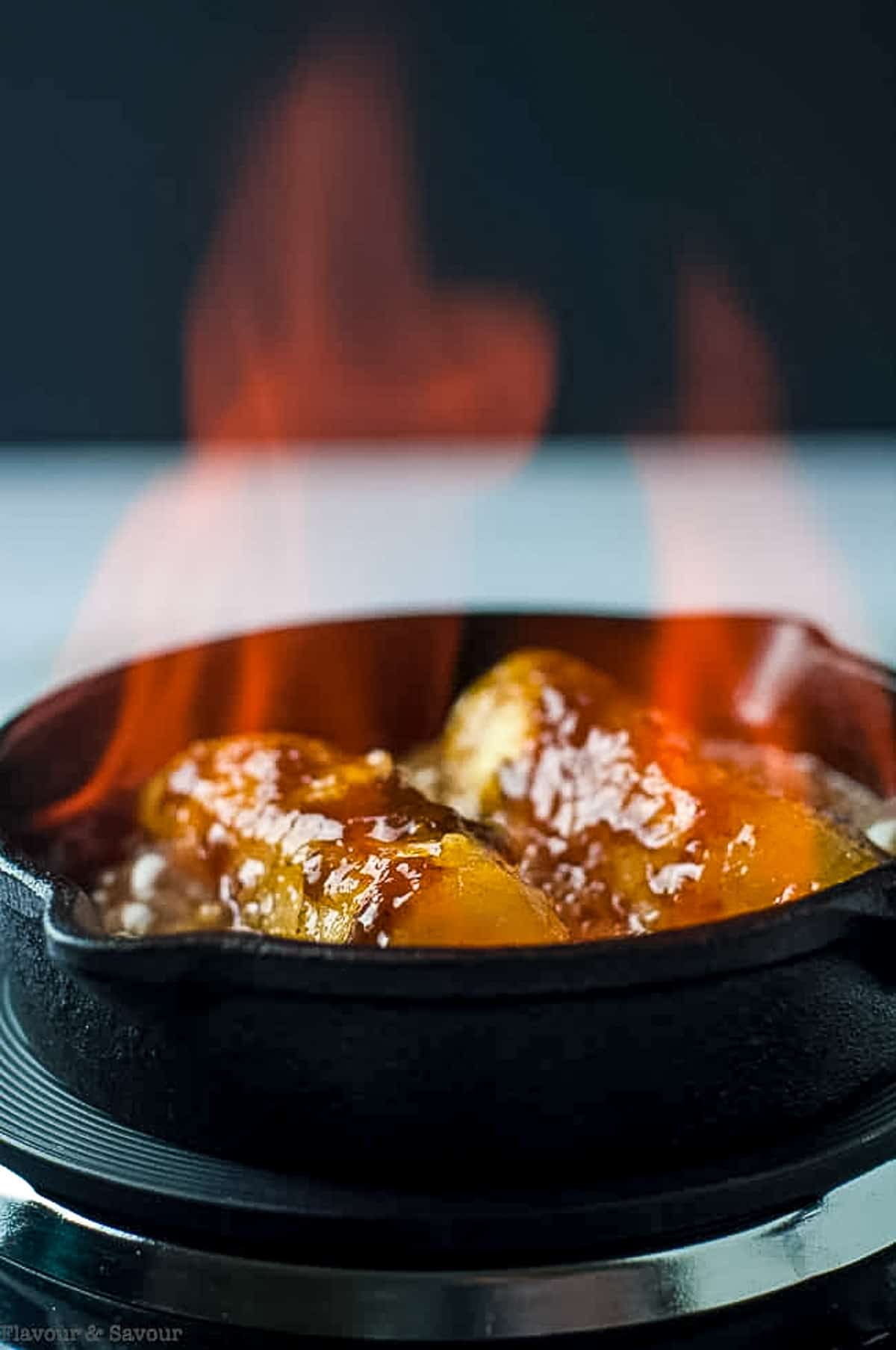 flaming bananas flambé in a small cast iron skillet