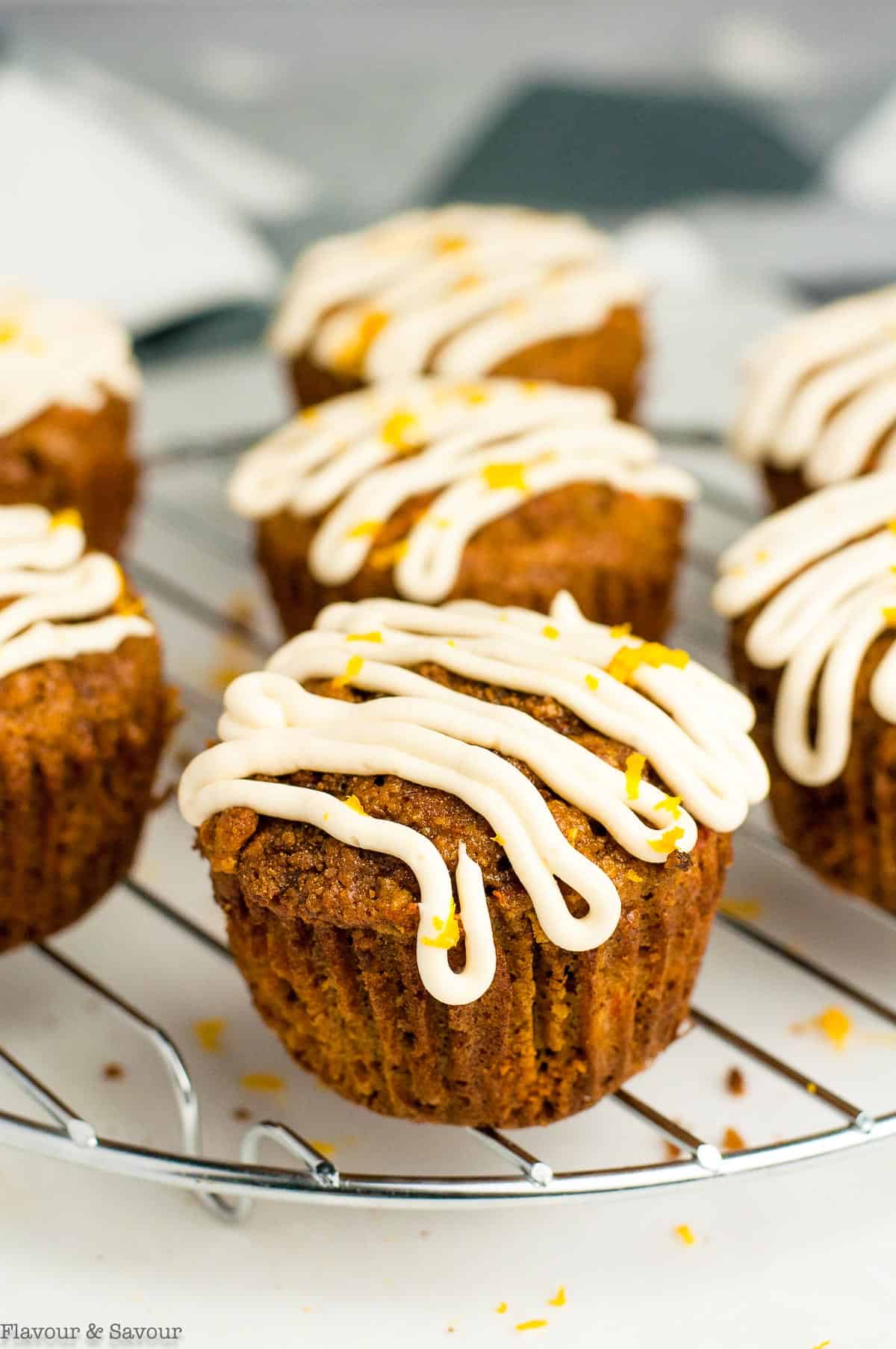 Carrot Ginger Muffins with cream cheese glaze on a cooling rack.