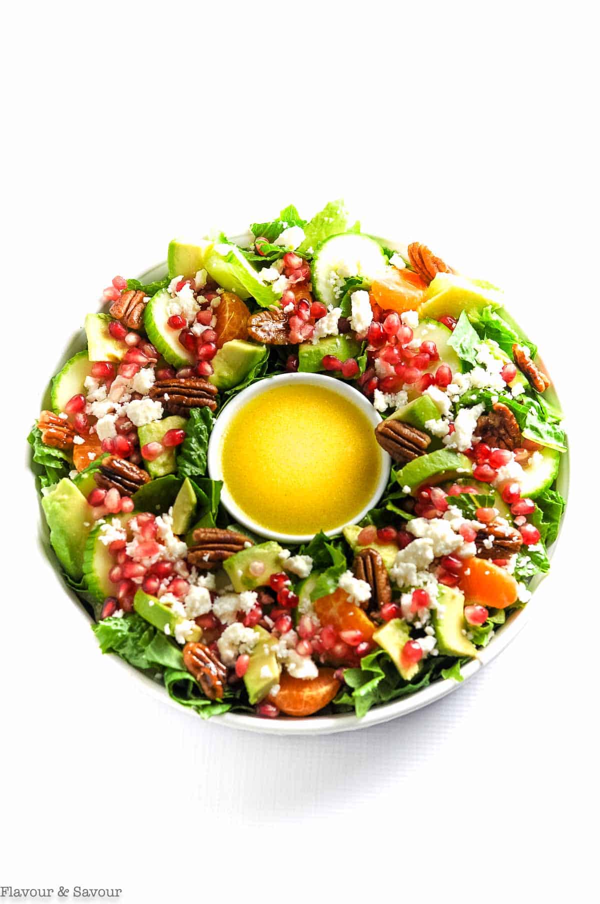 Overhead view of Christmas Wreath Salad with a bowl of dressing in the middle.