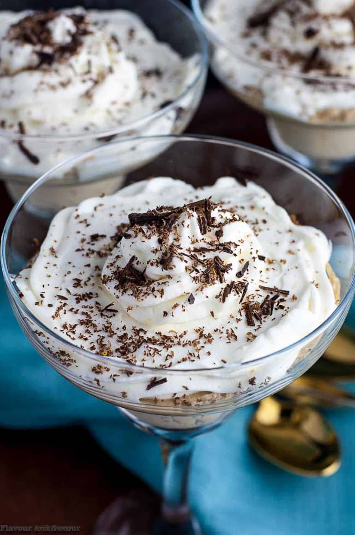 overhead view of a glass of ricotta coffee mousse topped with whipping cream and shaved chocolate