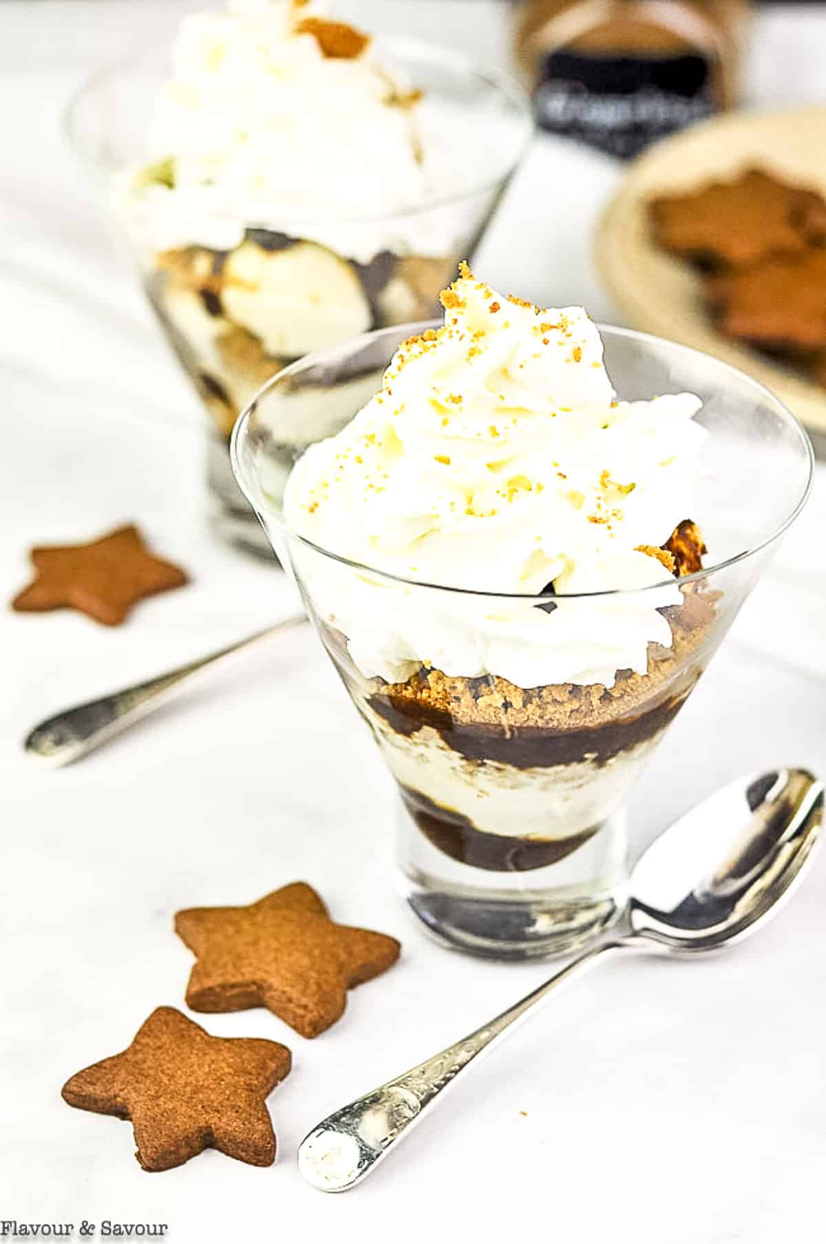 a dessert glass with a layered parfait with gingerbread sauce, gingersnaps and whipped cream