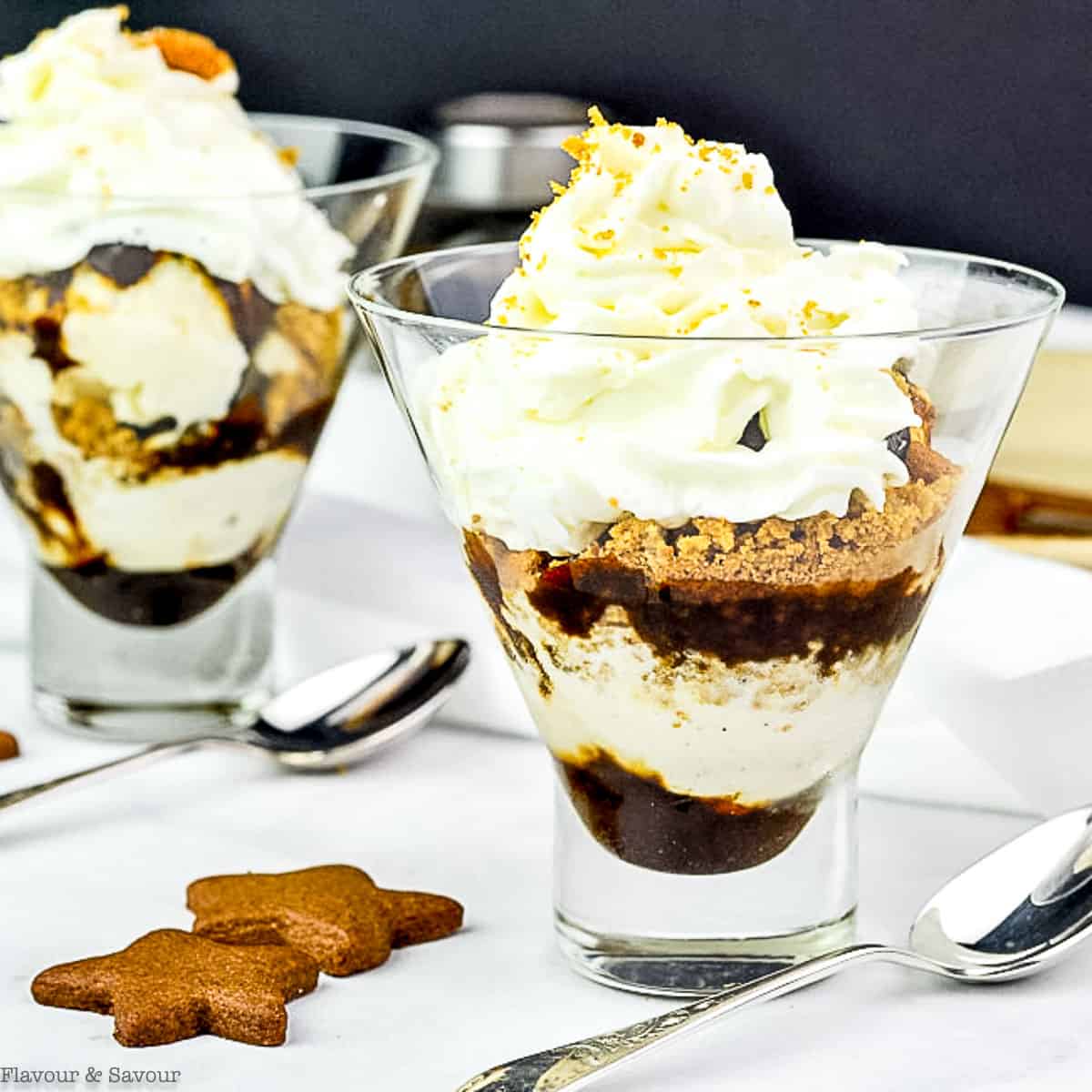 close up view of a glass filled with a layered gingerbread ice cream sundae