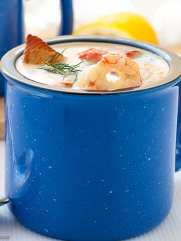 a blue mug filled with seafood chowder