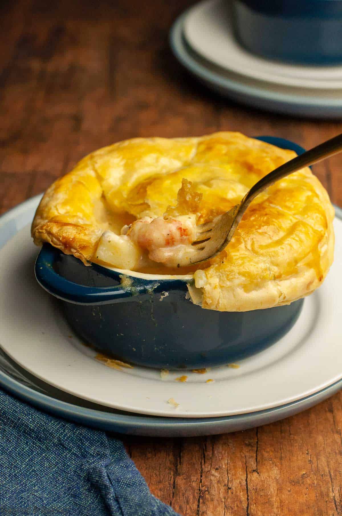 Seafood pot pie with puff pastry showing the seafood filling