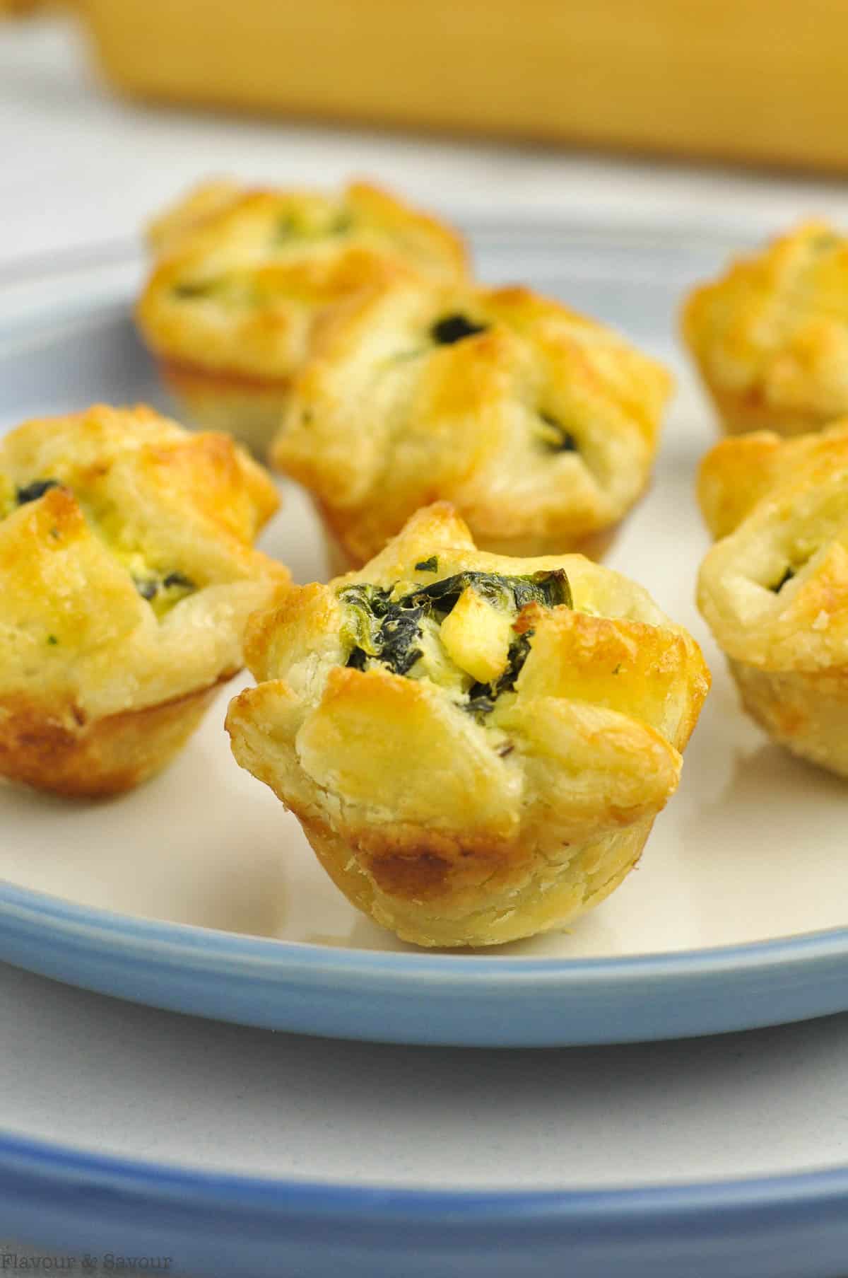 Spinach Artichoke Puff Pastry cups on a blue-rimmed plate