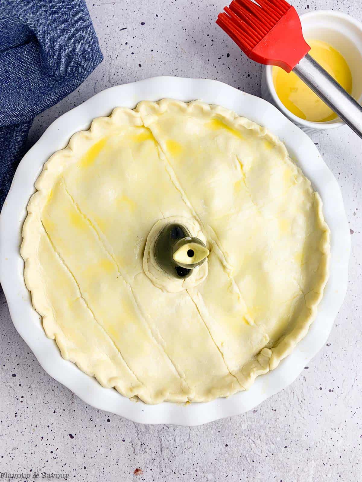 brushing puff pastry with egg wash to make mushroom pot pie