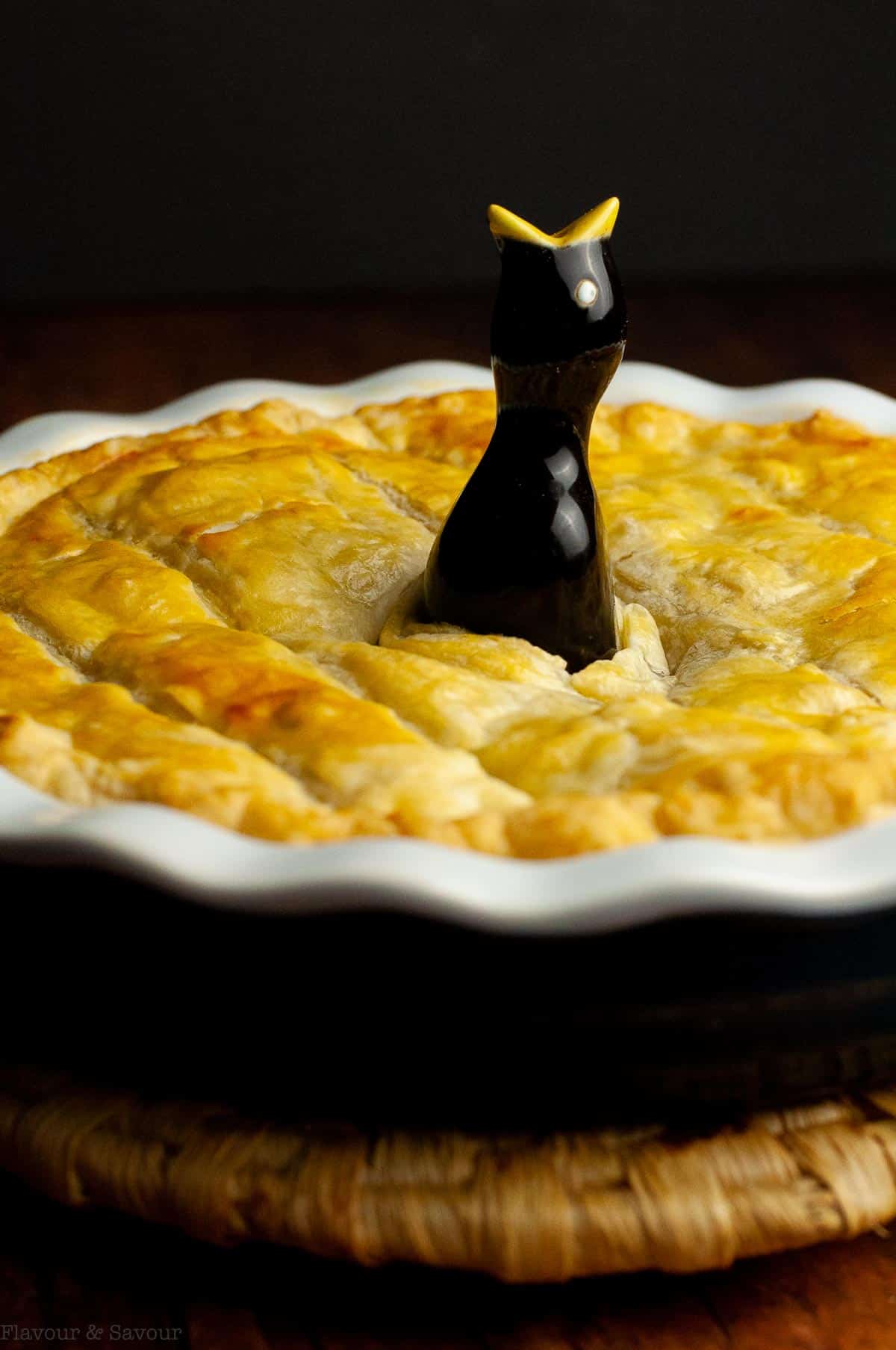 a baked vegetarian pot pie with puff pastry and a pie bird