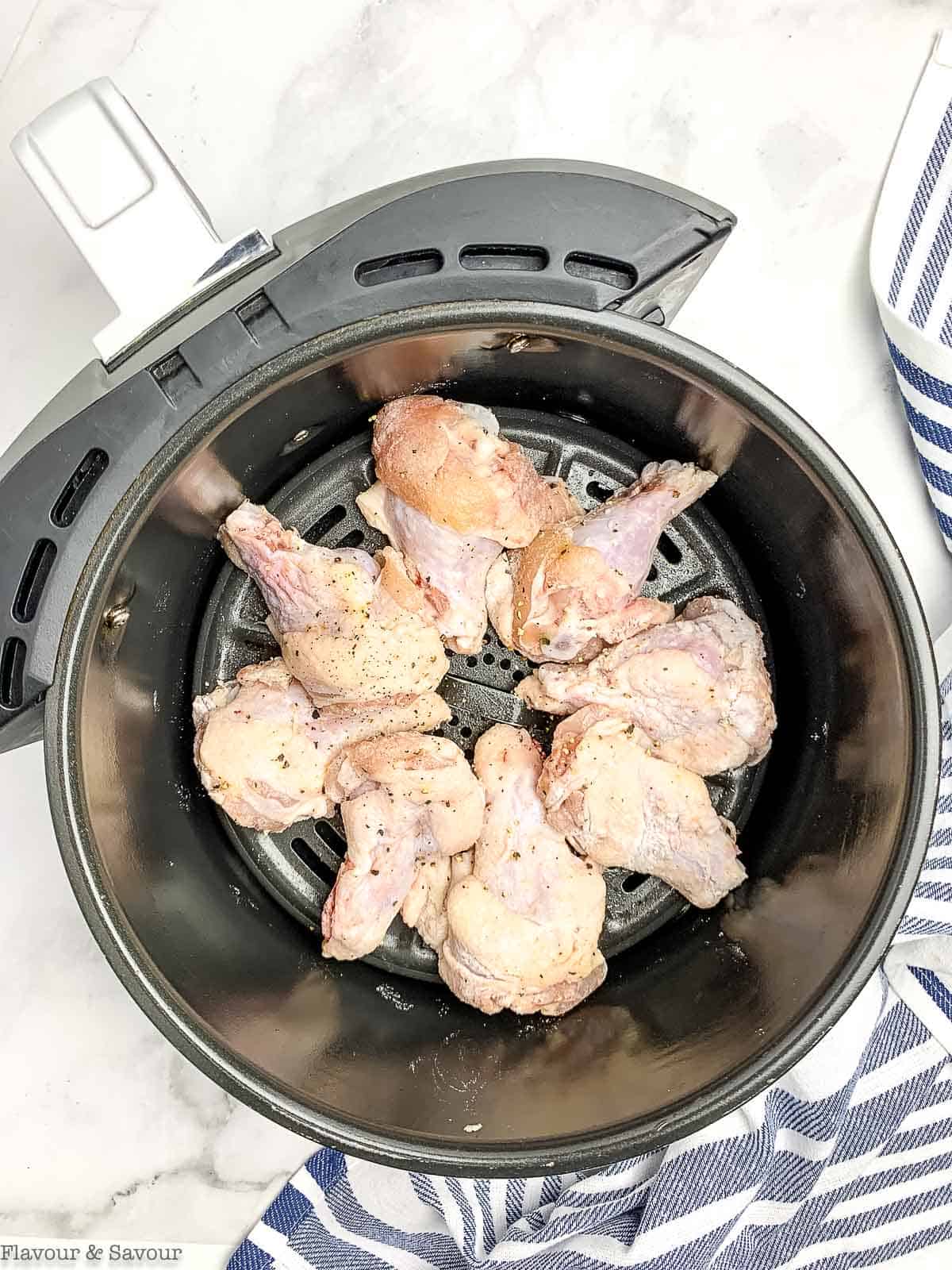 Chicken wings arranged in an air fryer basket.