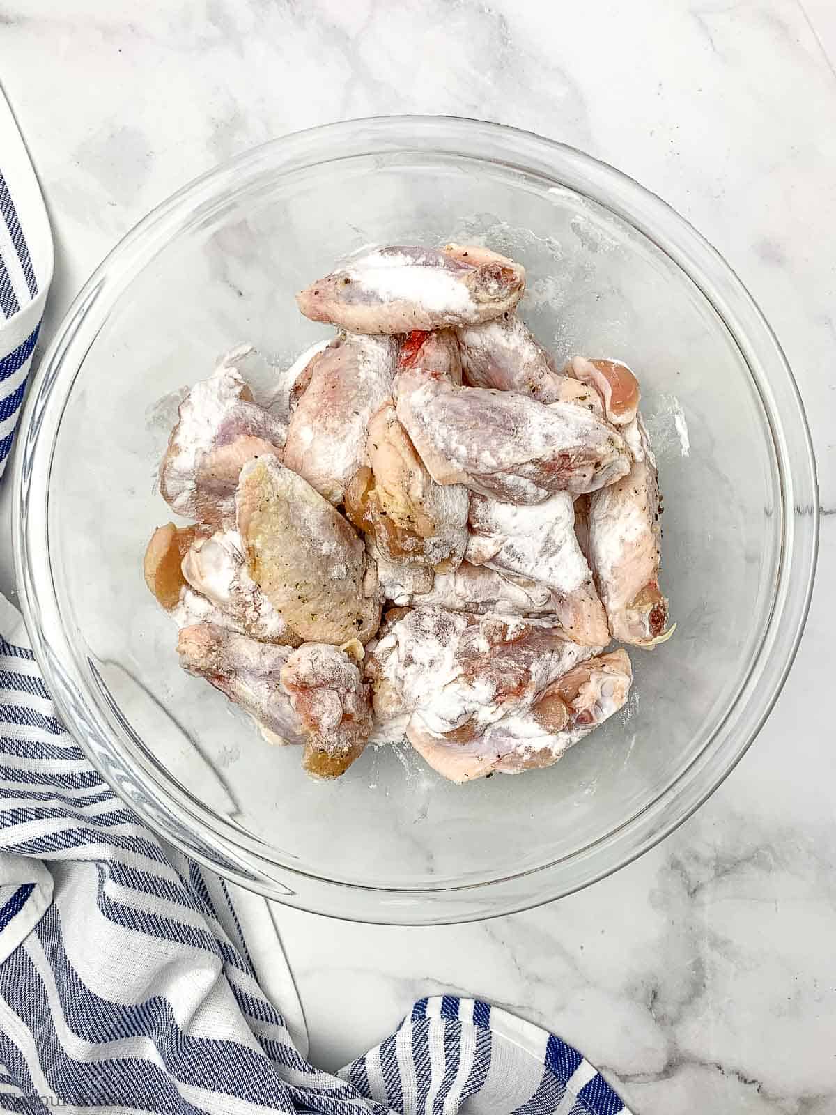 wings tossed with baking powder in a bowl.