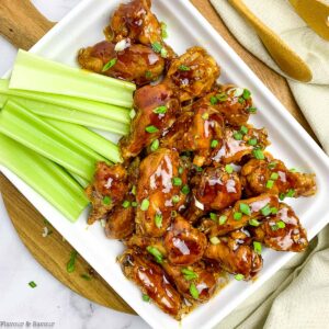 overhead view of air fryer honey garlic chicken wings served with celery sticksl
