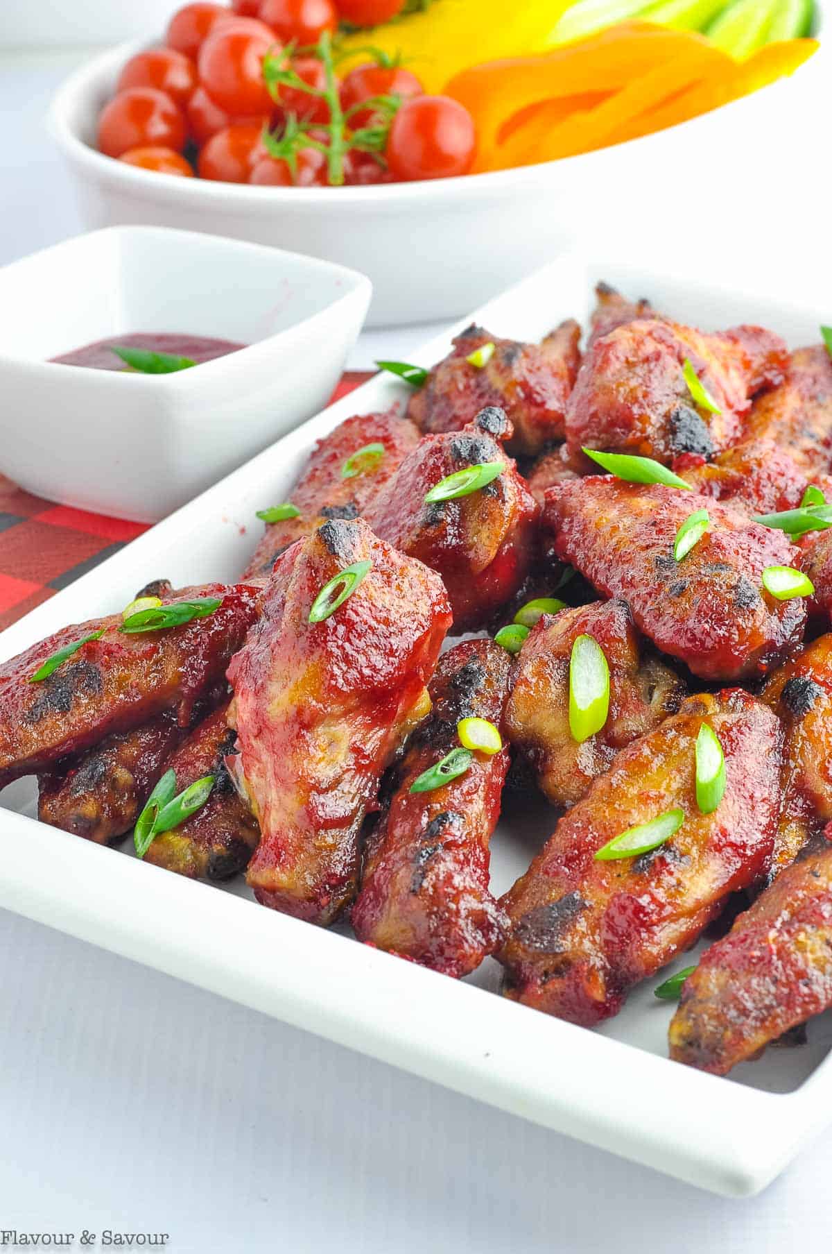a platter of cranberry glazed wings with chili sauce