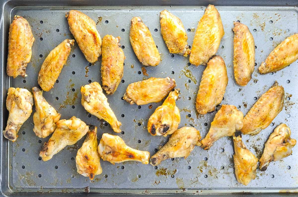 Cooked chicken wings on a sheet pan in a single layer.