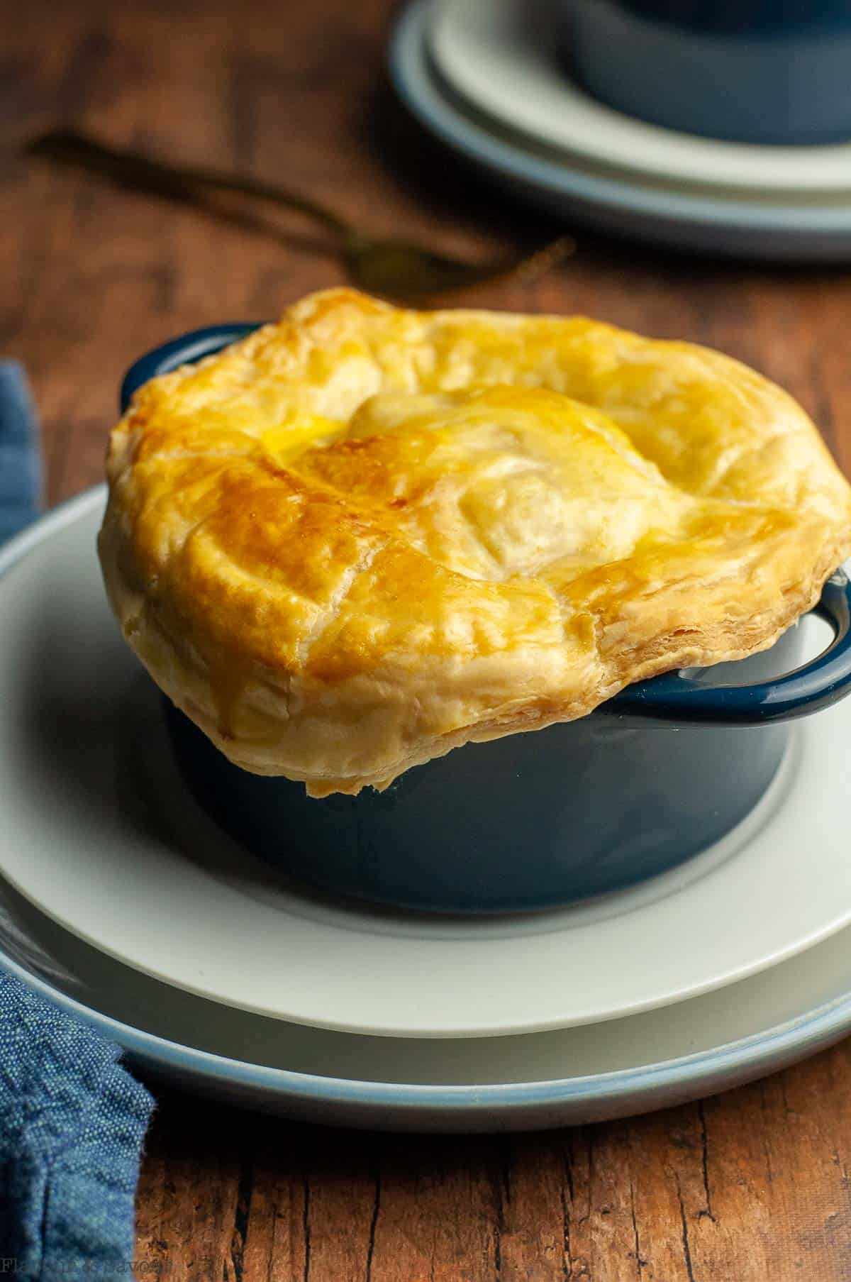 A cocotte dish with seafood pot pie covered in puff pastry.