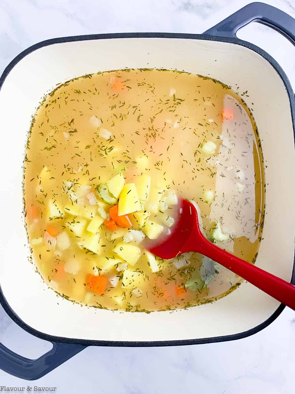simmering pot pie filling with broth, potatoes and vegetables