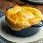 seafood pot pie with a puff pastry lid in a small blue casserole dish