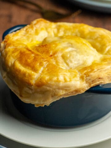 seafood pot pie with a puff pastry lid in a small blue casserole dish