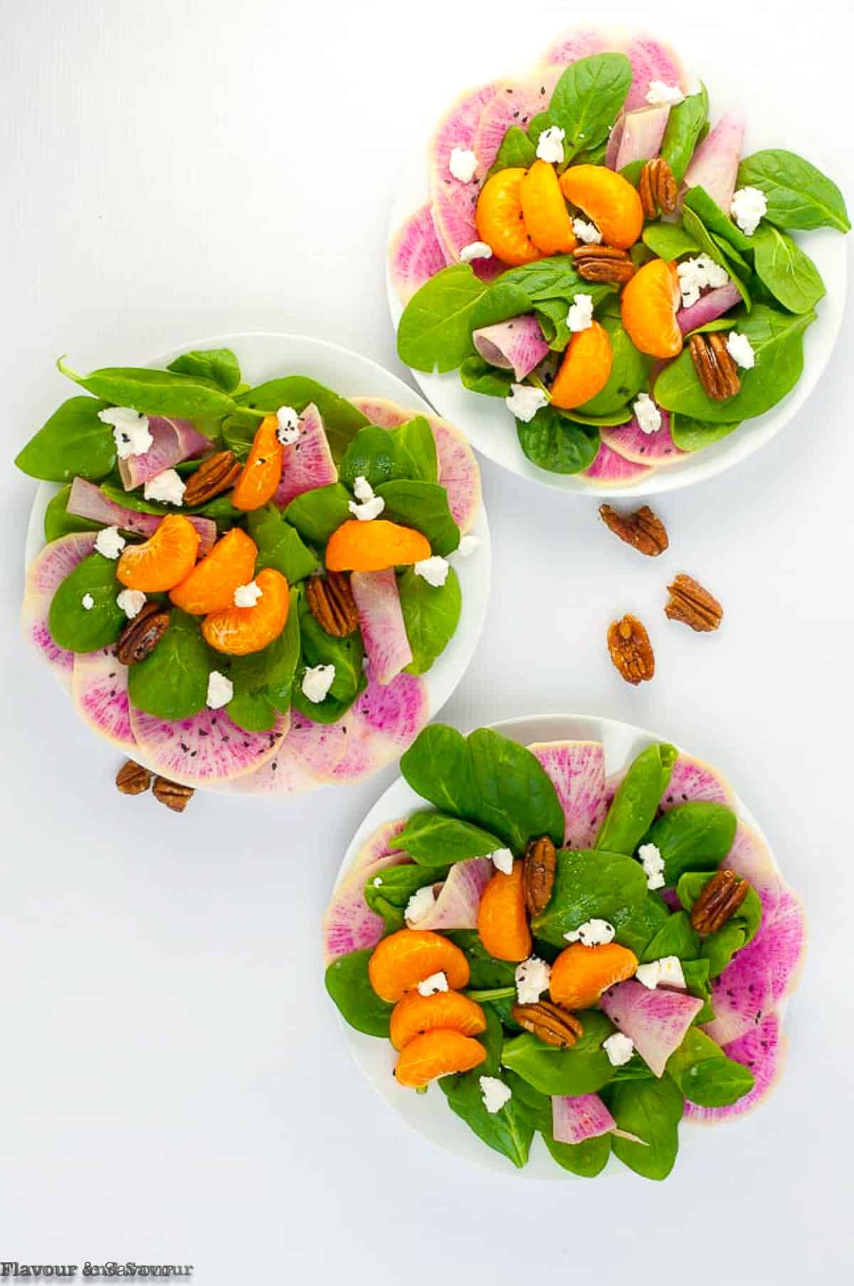 three plates of winter salads with  watermelon radishes and oranges