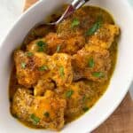 a bowl of Honey Dijon Turmeric Chicken Thighs with a serving spoon