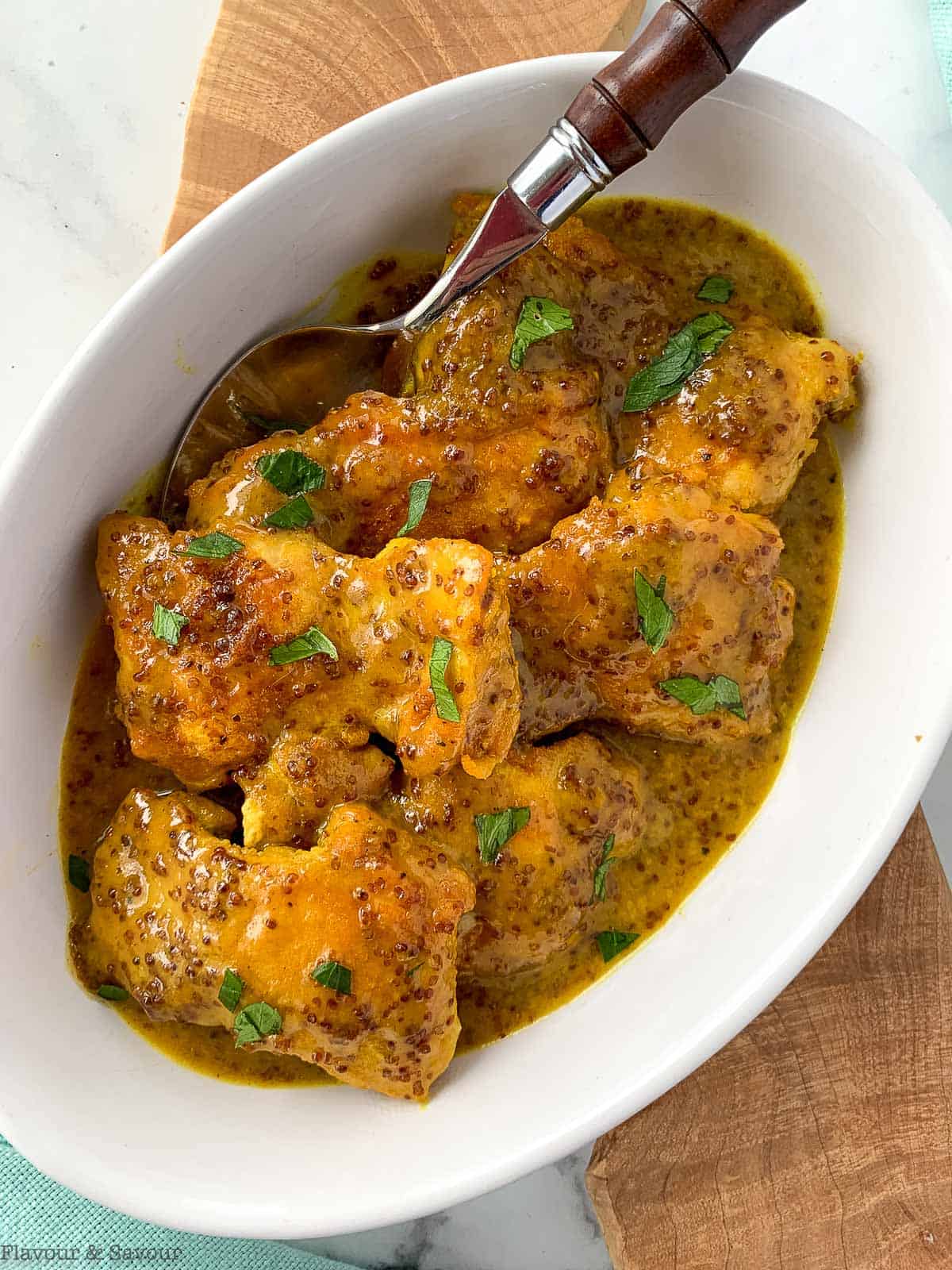 Honey Dijon Turmeric Chicken Thighs in a bowl with a spoon