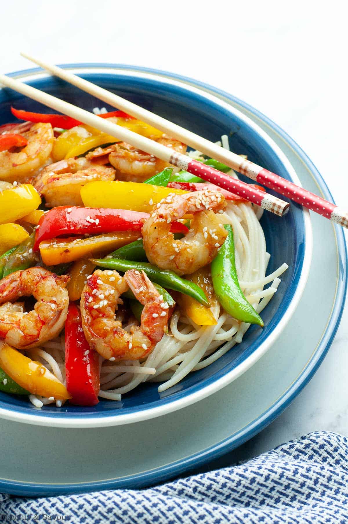 a bowl of stir fry over noodles with shrimp