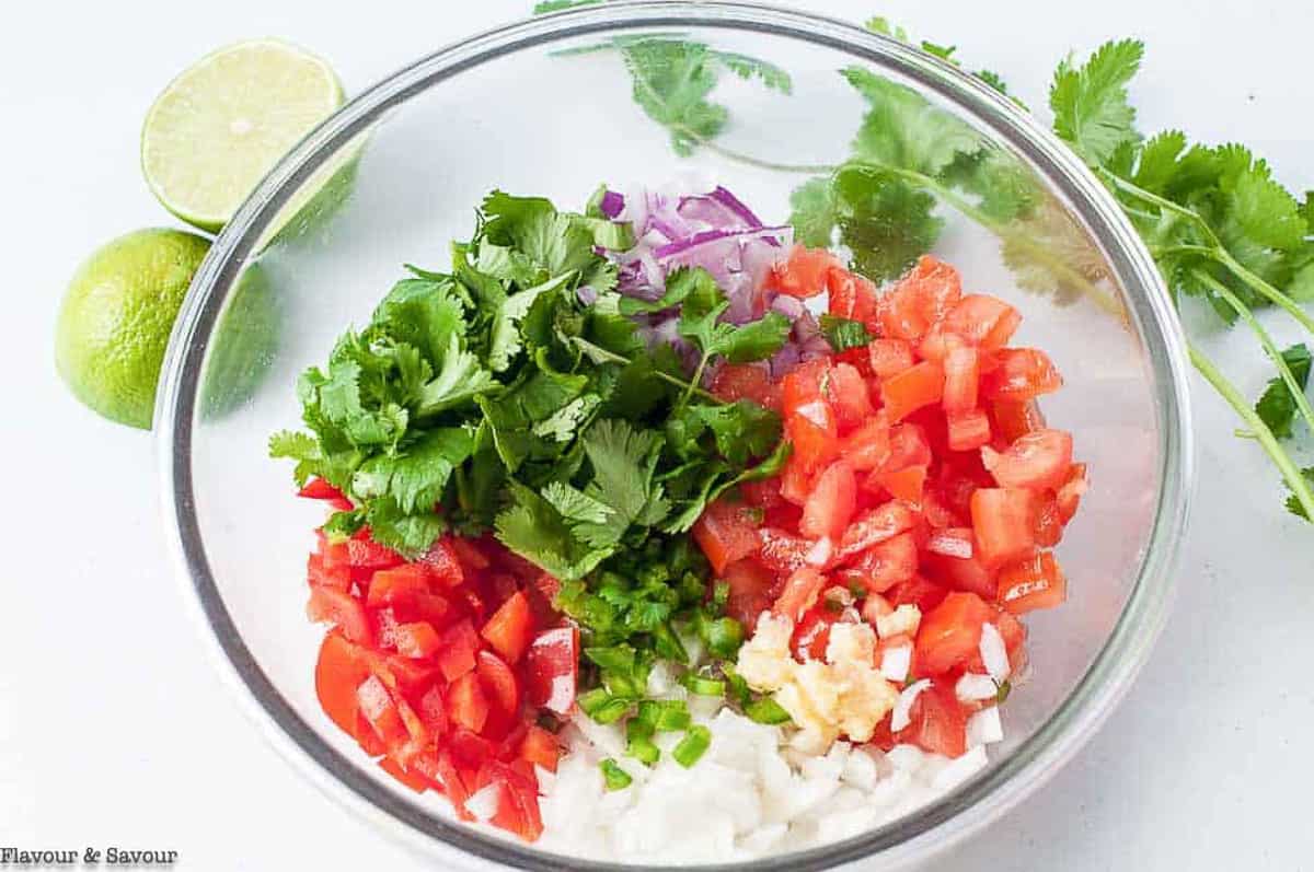 ingredients for fresh salsa in a glass bowl
