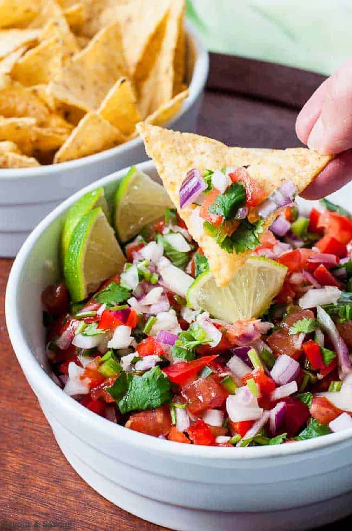 scooping fresh salsa with a tortilla chip