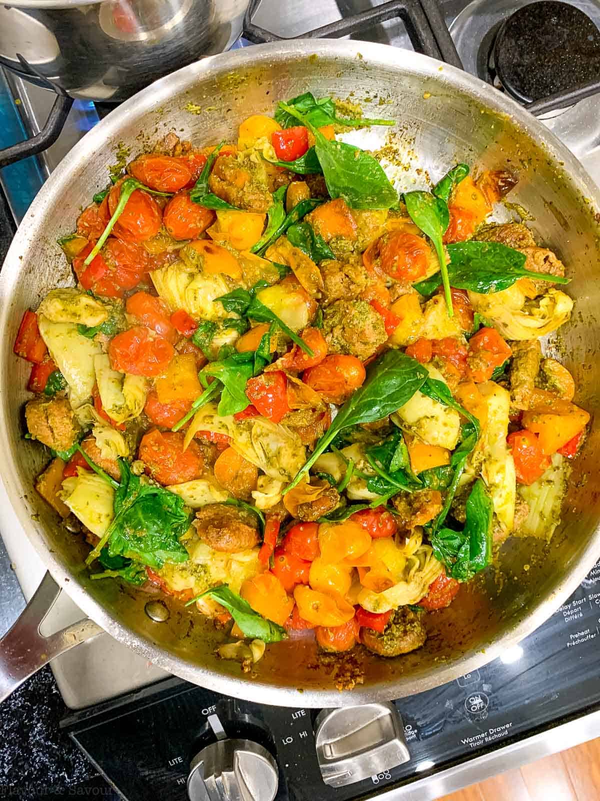 Adding browned sausage to Pesto Gnocchi.