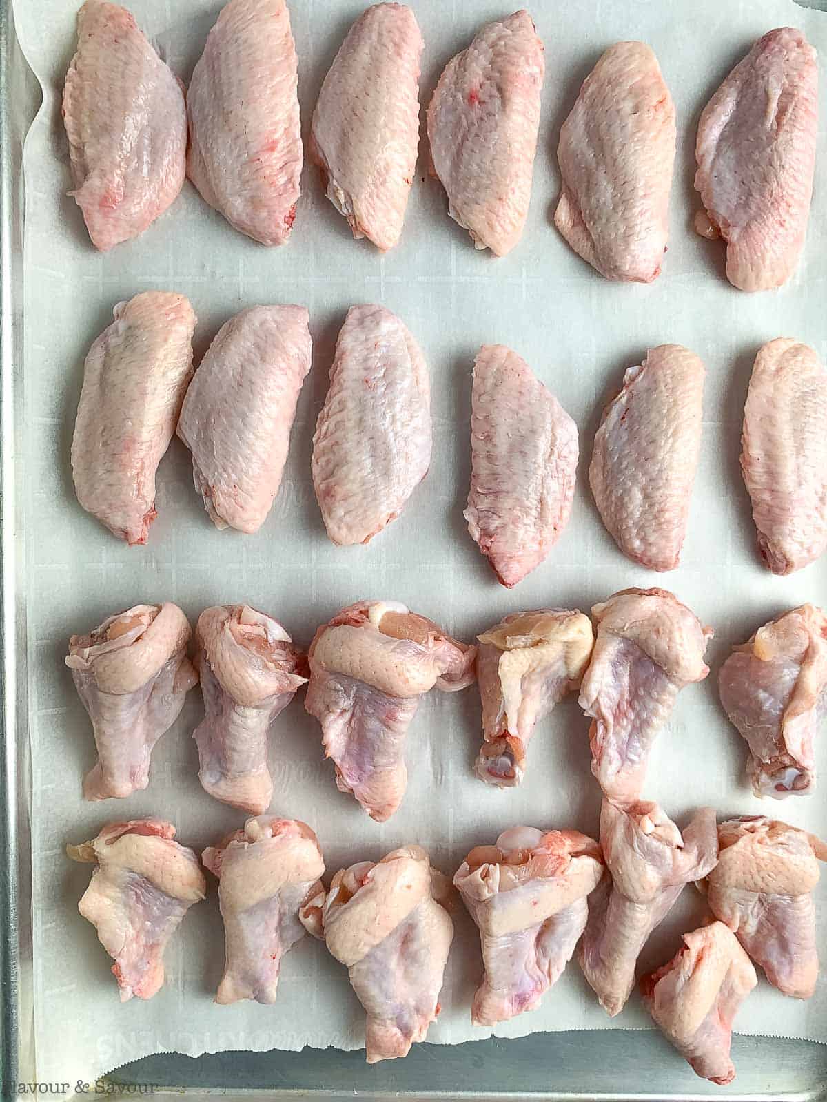 Raw chicken wings on a baking sheet.