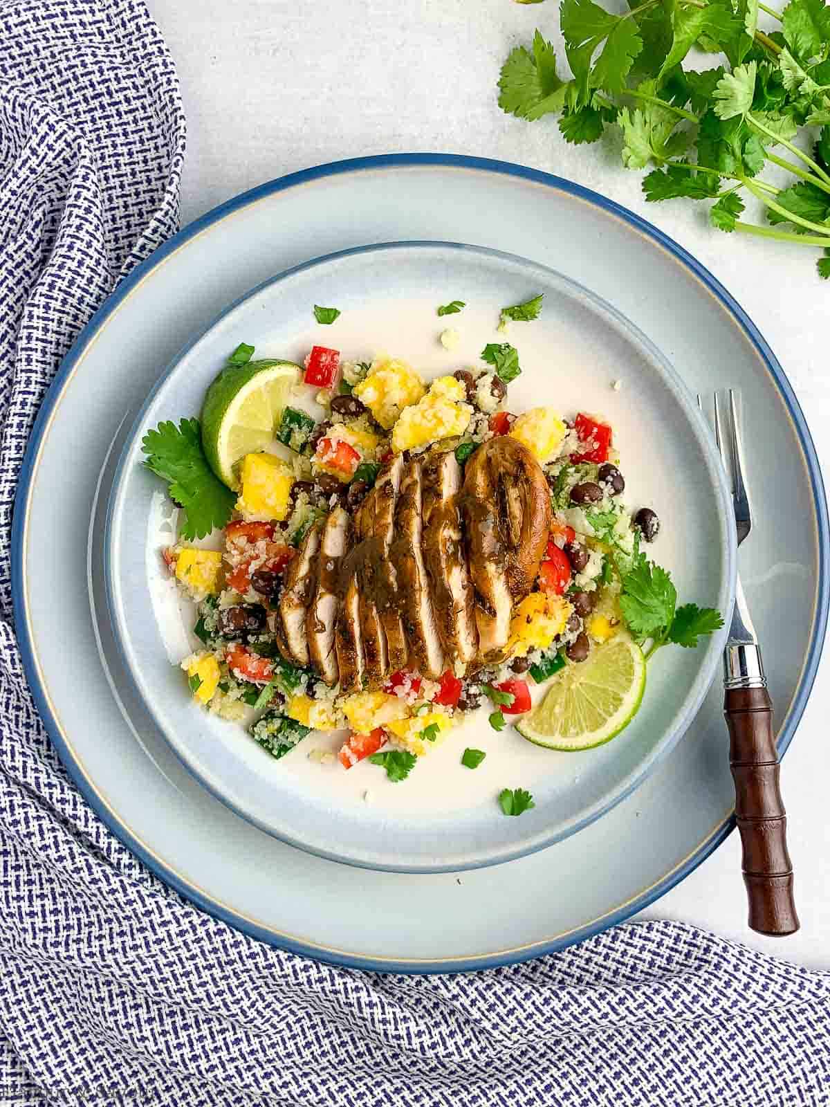 Overhead view of a sliced Caribbean Jerk Chicken Breast on top of cauliflower couscous salad.