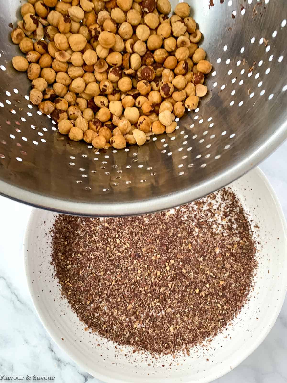 Separate hazelnuts from their skins by shaking them in a sieve.