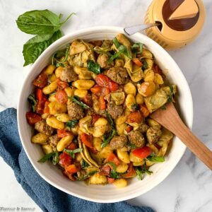 overhead view of a round bowl of gnocchi with pesto and vegetables