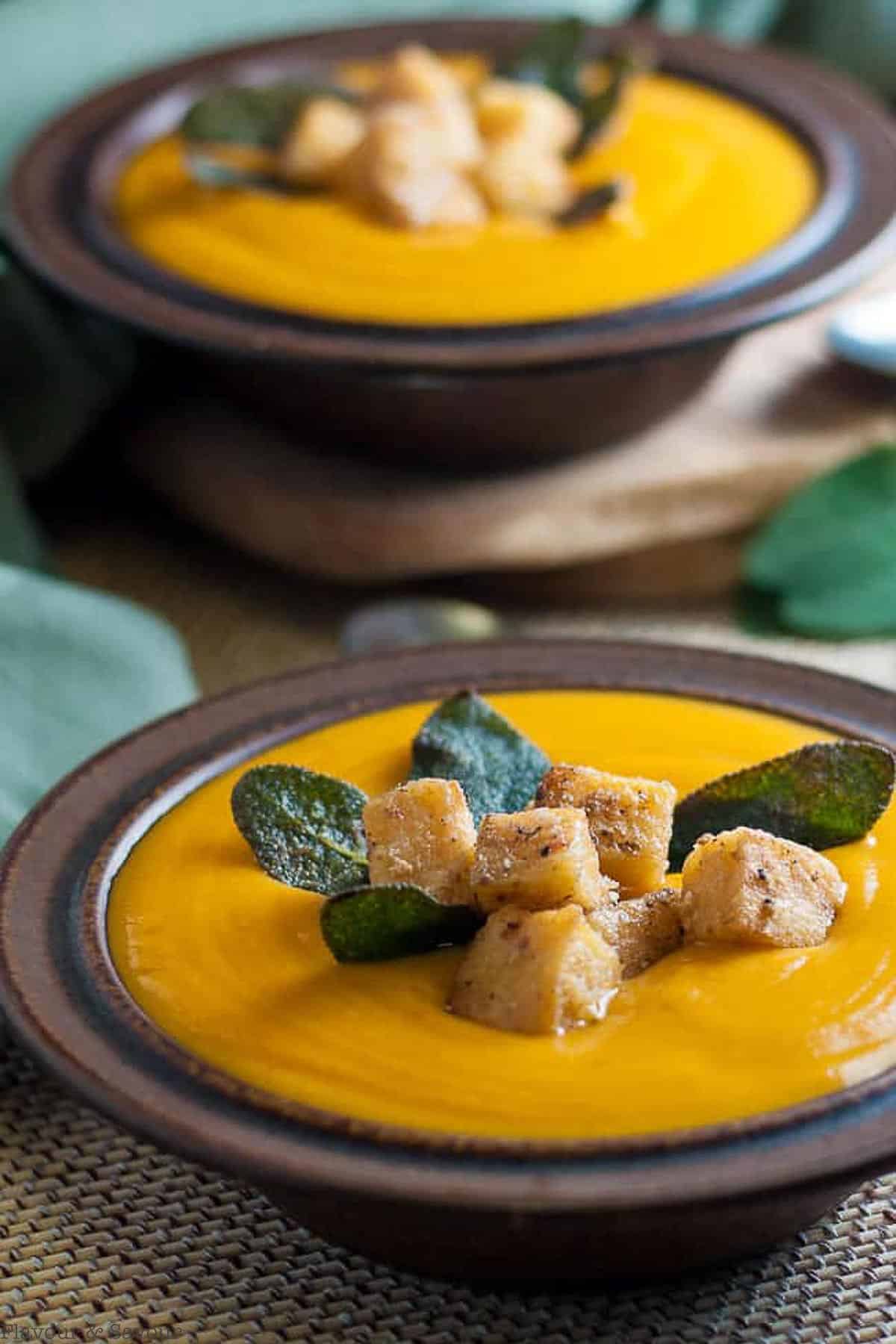 close up view of a bowl of chipotle sweet potato soup with polenta croutons