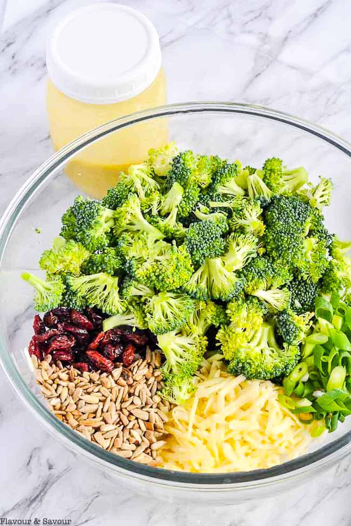 a bowl will all the ingredients for Honey-Dijon Broccoli Salad