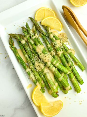 asparagus spears with lemon tahini dressing and hemp hearts