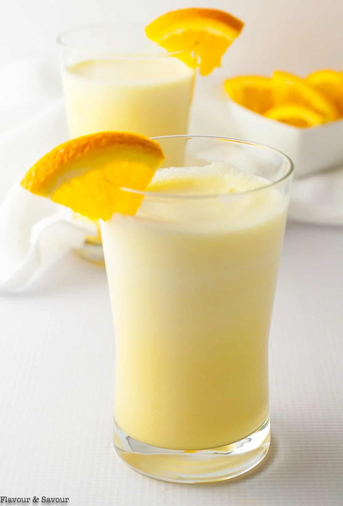 orange collagen smoothie garnished with orange wedges