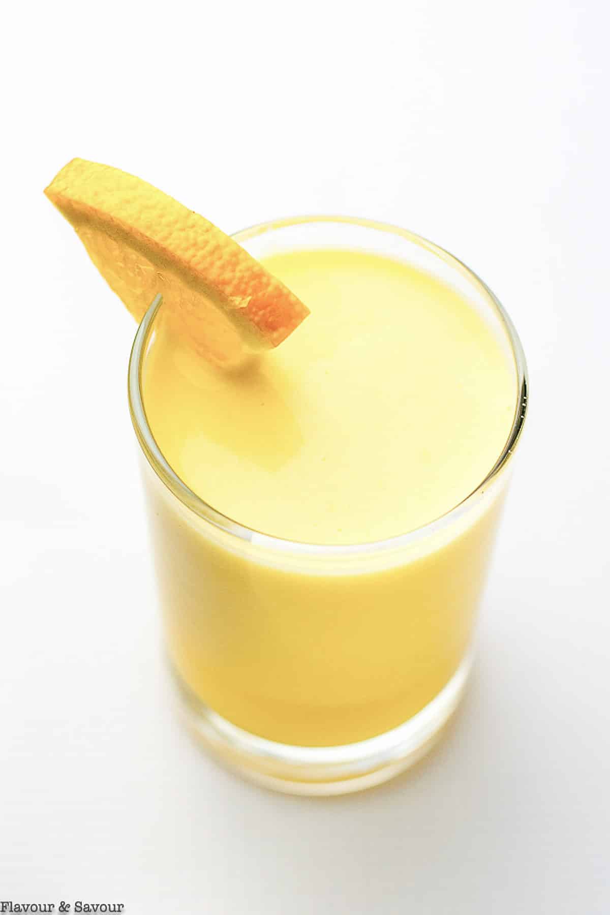 overhead view of a glass of orange smoothie with collagen