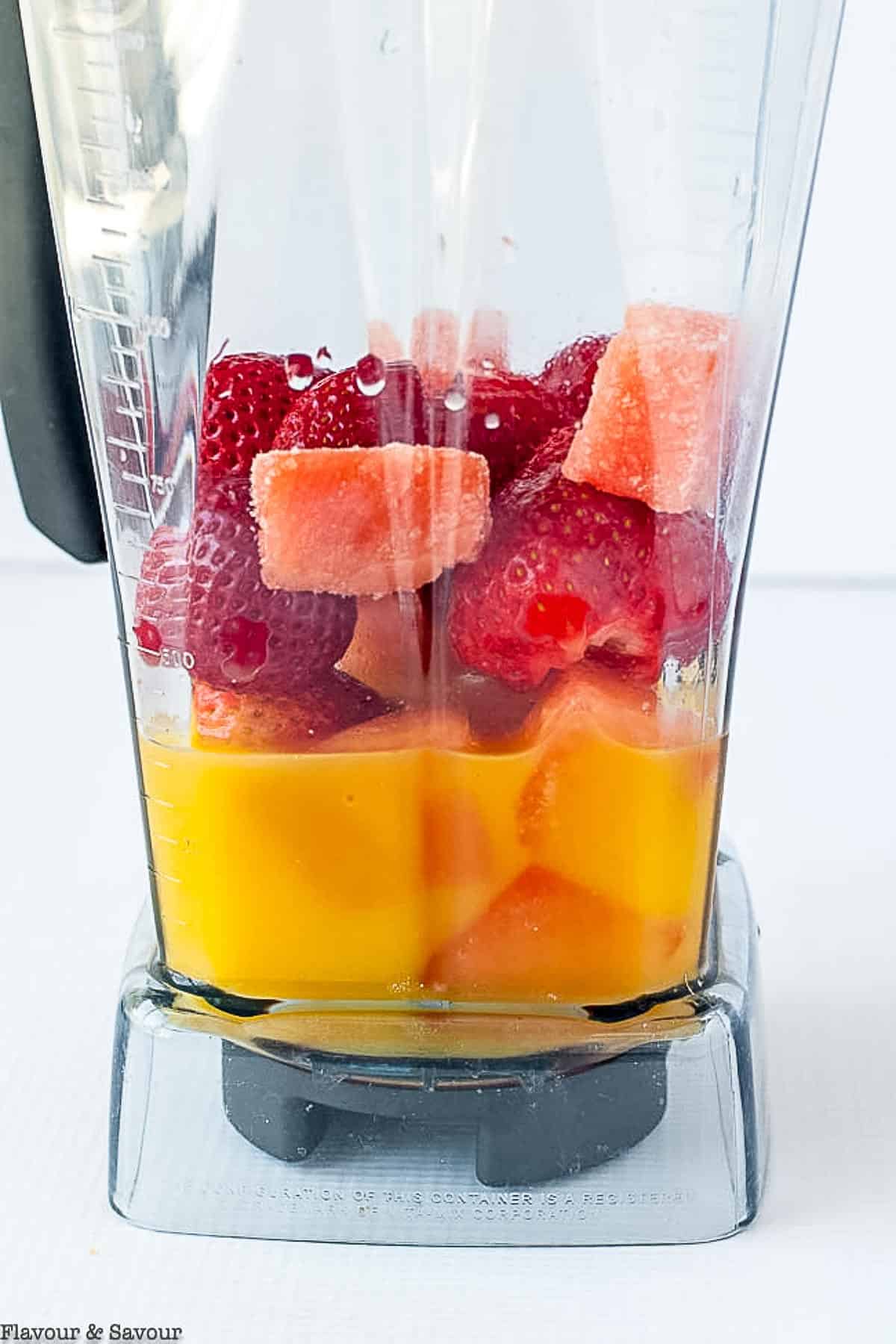Ingredients for strawberry watermelon smoothie in a blender container.