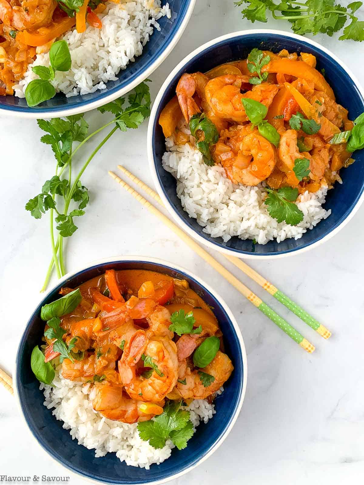 two blue bowls with rice and Thai red curry with shrimp