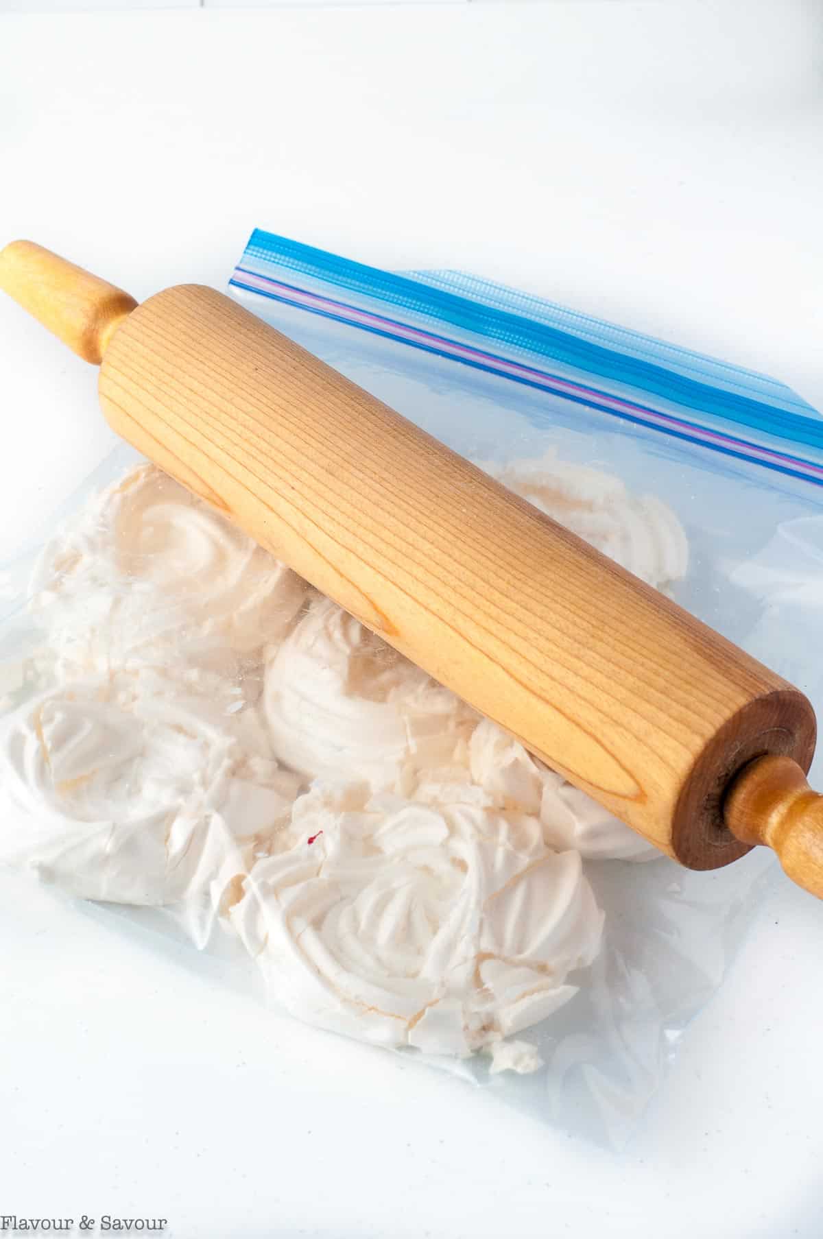 Crushing meringues in a resealable bag with a rolling pin.