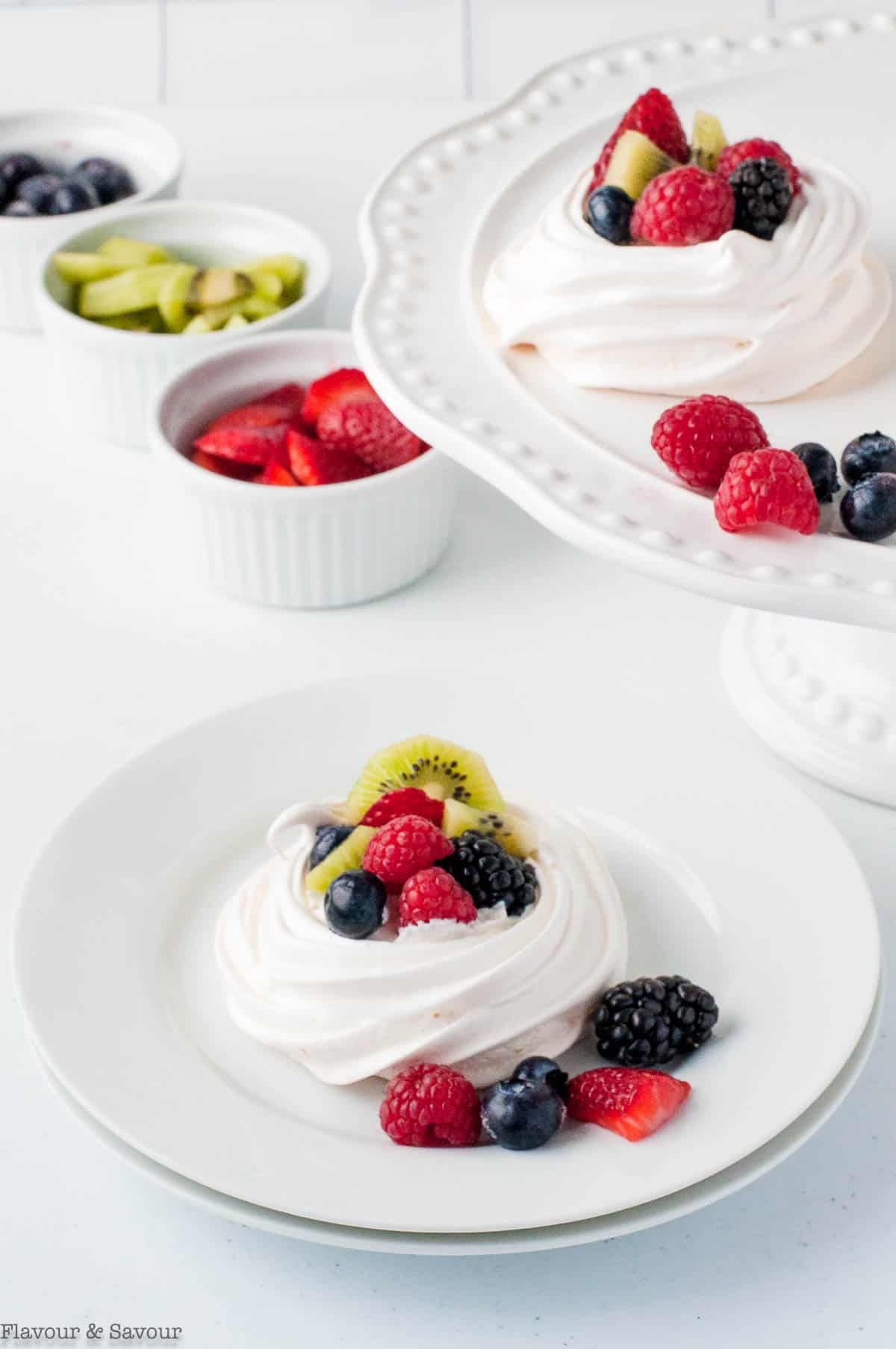 Mini pavlova desserts decorated with fresh berries and kiwi.
