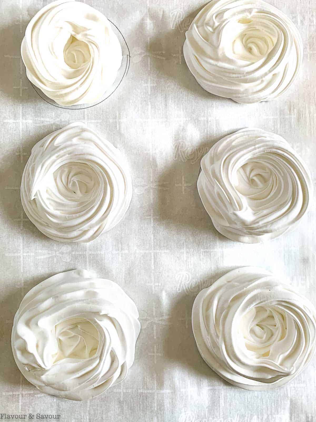 Meringue nests on a baking sheet.