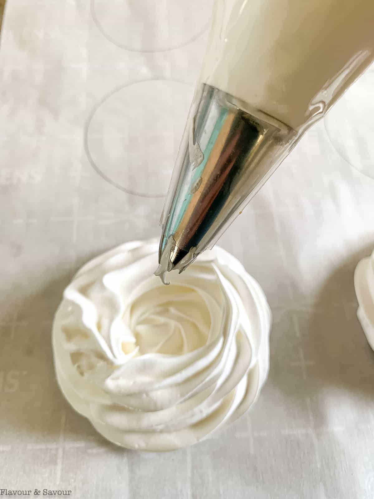 Using a piping tube to form meringue nests for pavlova.