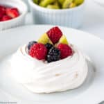 Mini Pavlova topped with fresh berries and kiwi fruit.