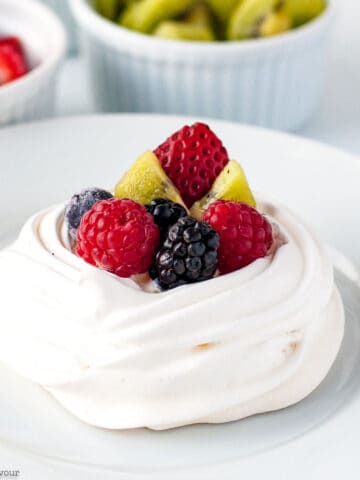 Mini Pavlova topped with fresh berries and kiwi fruit.