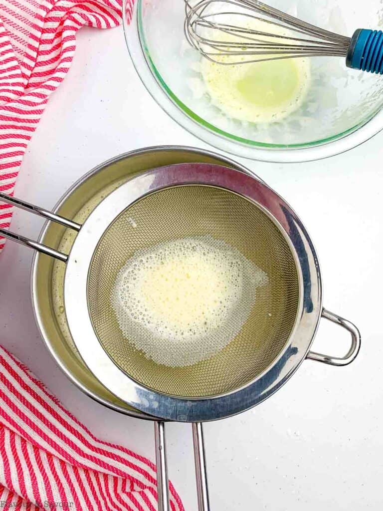 straining egg mixture for vanilla pastry cream.