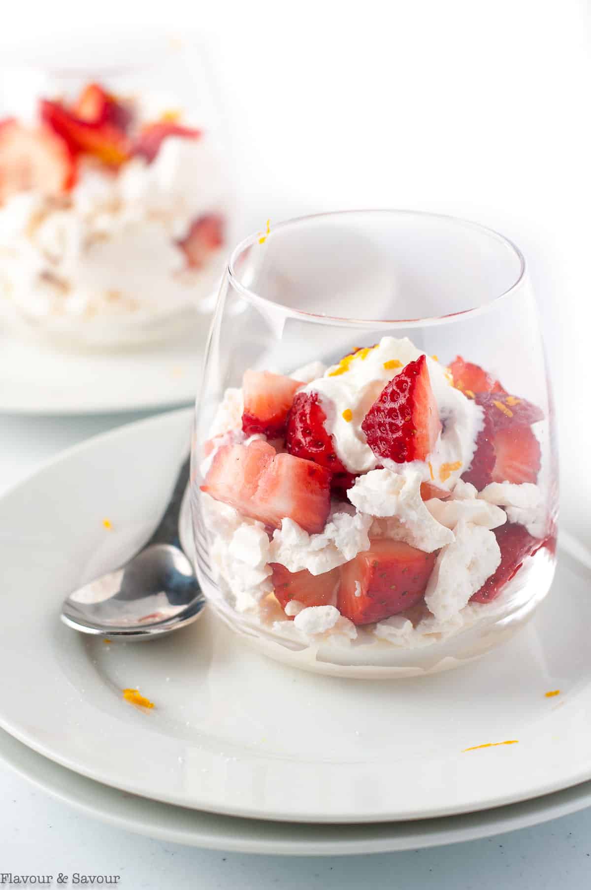 two glasses of traditional Strawberry Eton Mess with a spoon.