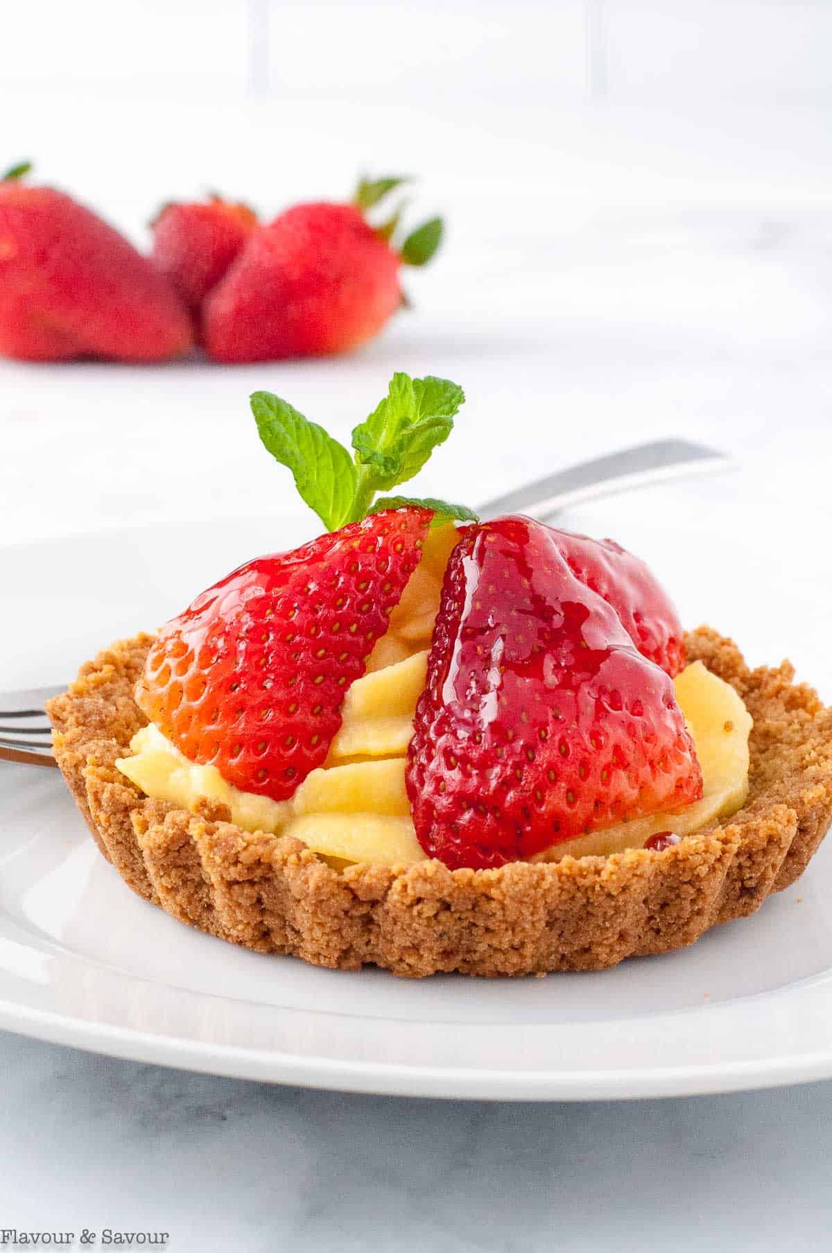 Strawberry tartlet with vanilla pastry cream, slice strawberries and a gluten-free graham cracker crust.